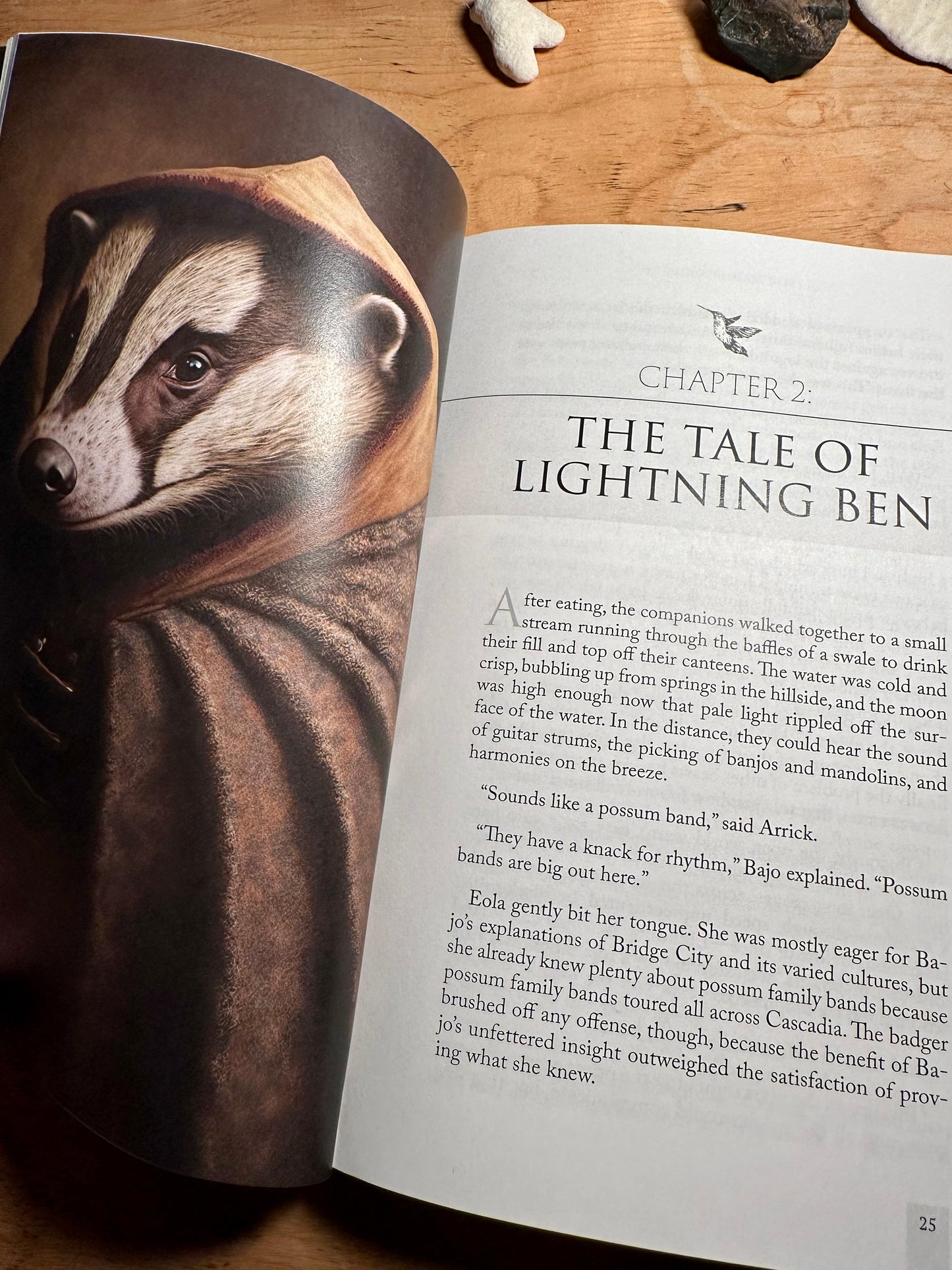 The blue beacon paperback opened to chapter 2, and an image of an American badger wearing a brown cloak named Eola Lightstripe. The title of the second chapter is the tale of lightning ben